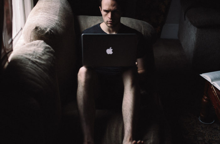 Mężczyzna z surową miną, siedzący przed komputerem